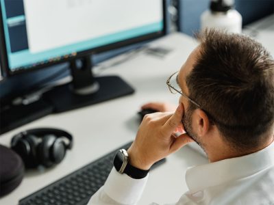 Bildschirm Hinterkopf eines Mannes, der auf einen Computerbildschirm schaut.